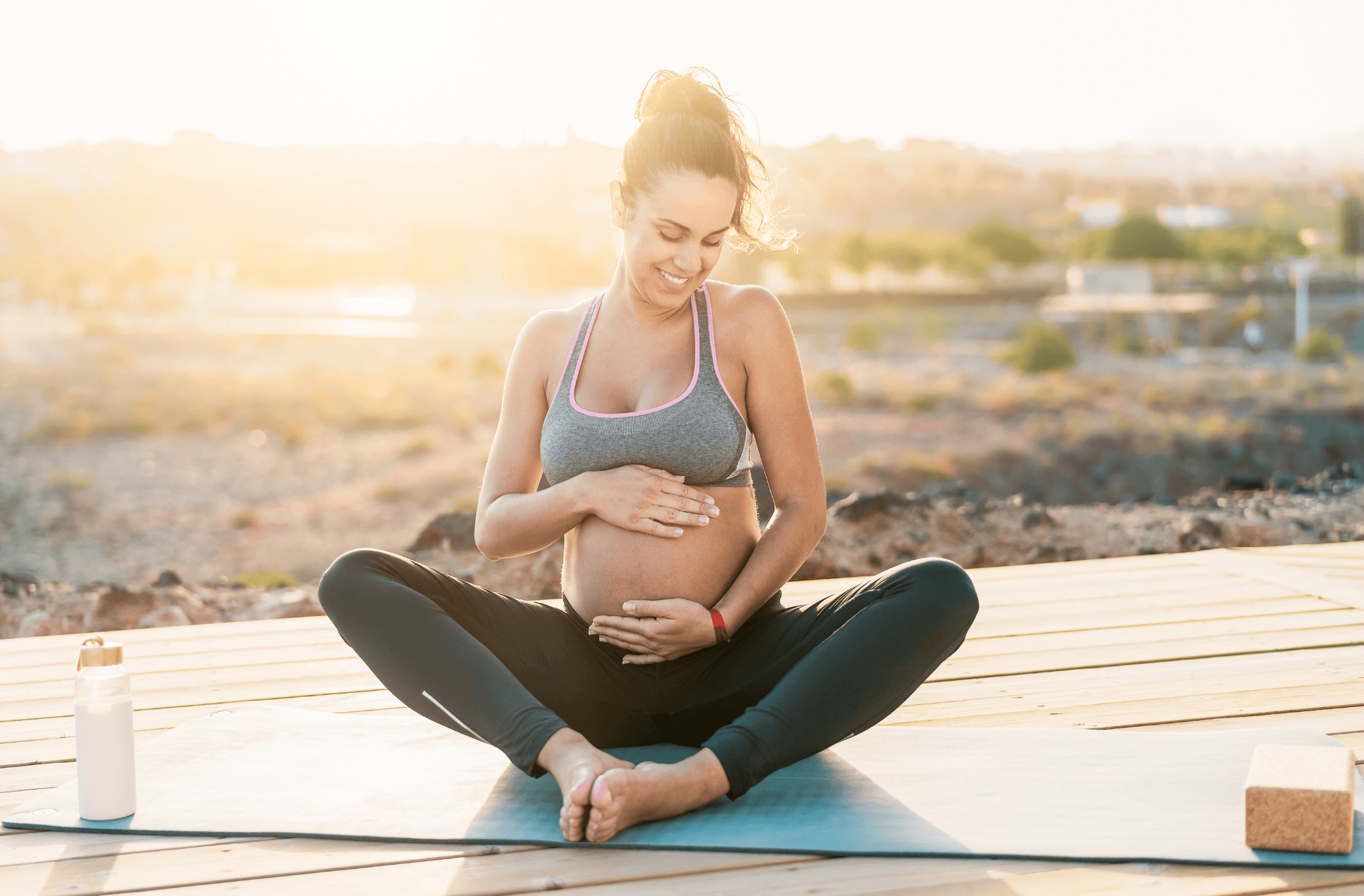 Une femme enceinte installée dans une posture de yoga