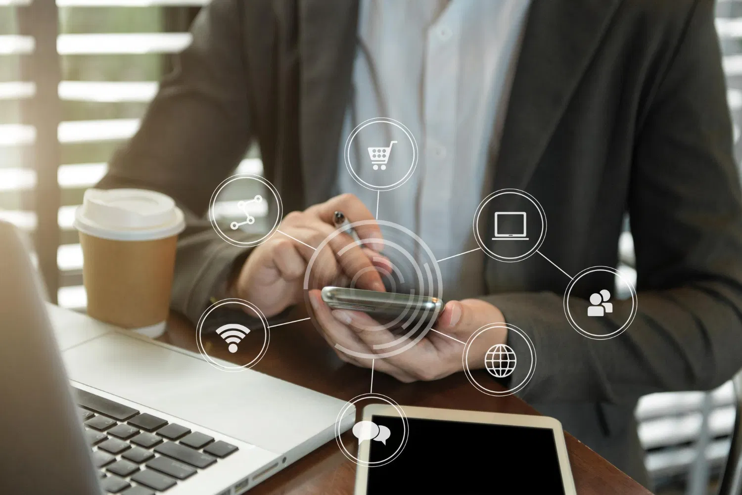 Professional using smartphone and laptop with connected marketing icons, WaveMed omnichannel marketing support