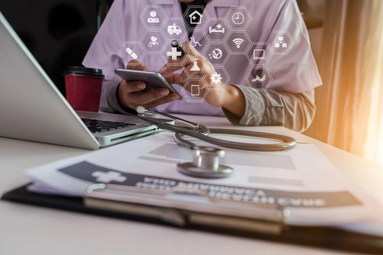 Doctor using smartphone and laptop with digital icons, WaveMed medical marketing and communication support