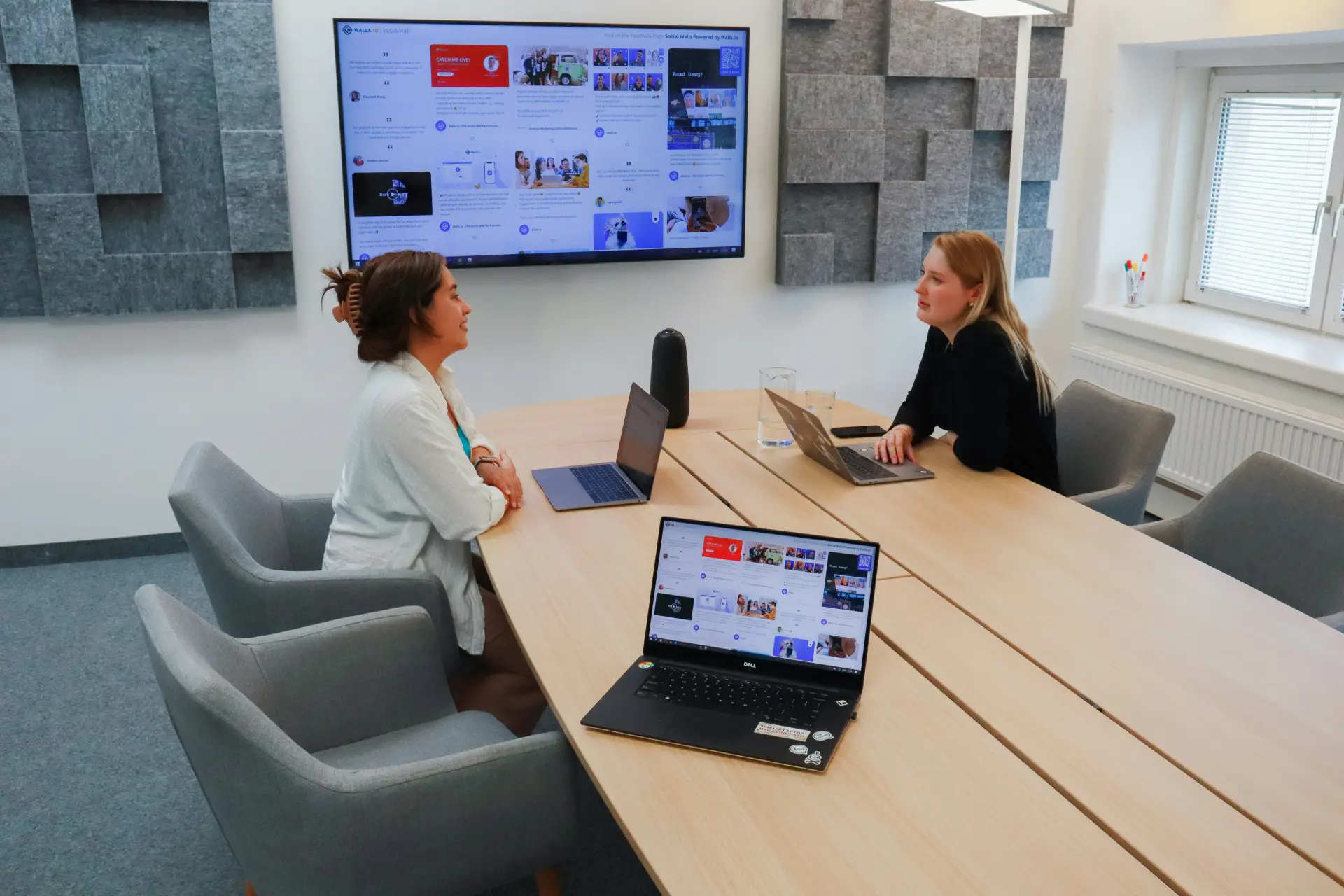 Two people discuss training materials at a table during individual or group learning in medical communications