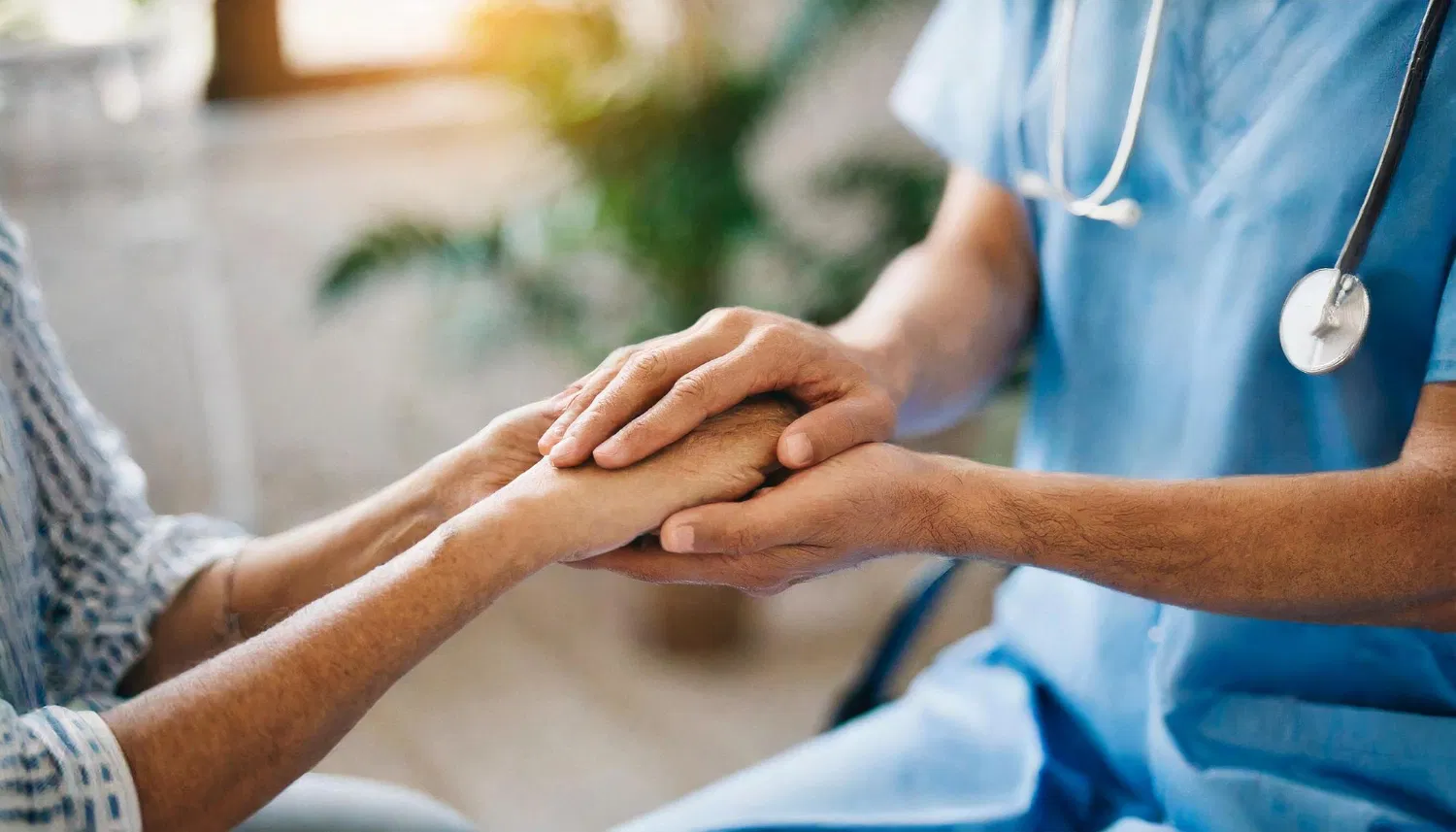 Doctor holding a patient's hand as a symbol of patient educational materials supported by WaveMed agency