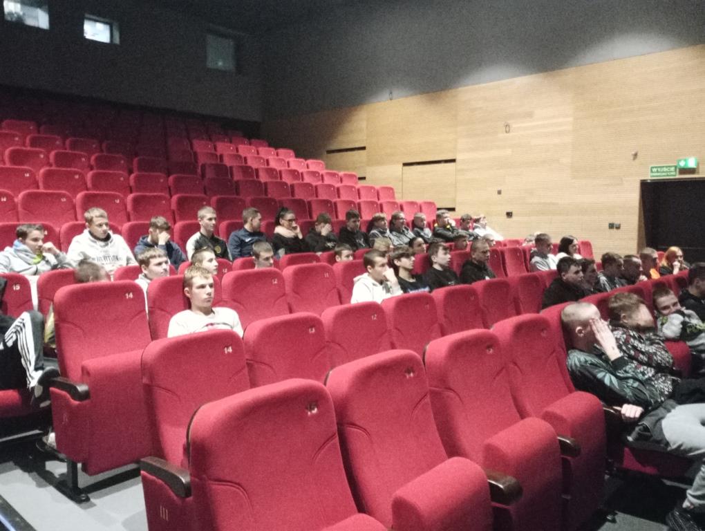 Spektakl profilaktyczny | Widownia teatru widziana z boku, w kilku pierwszych rzędach na czerwonych krzesłach siedzą wychowankowie MOW.jpg