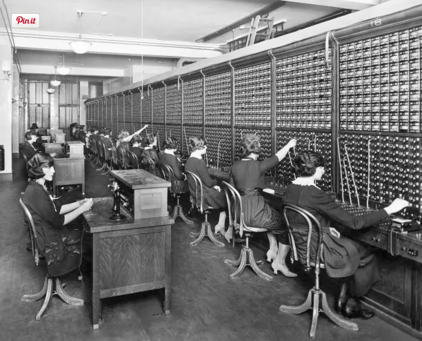 Women operating telephone switchboards in a vintage office setting