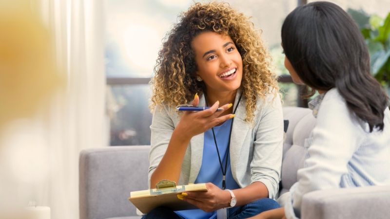 Een vrouw voert een keukentafelgesprek met een andere vrouw