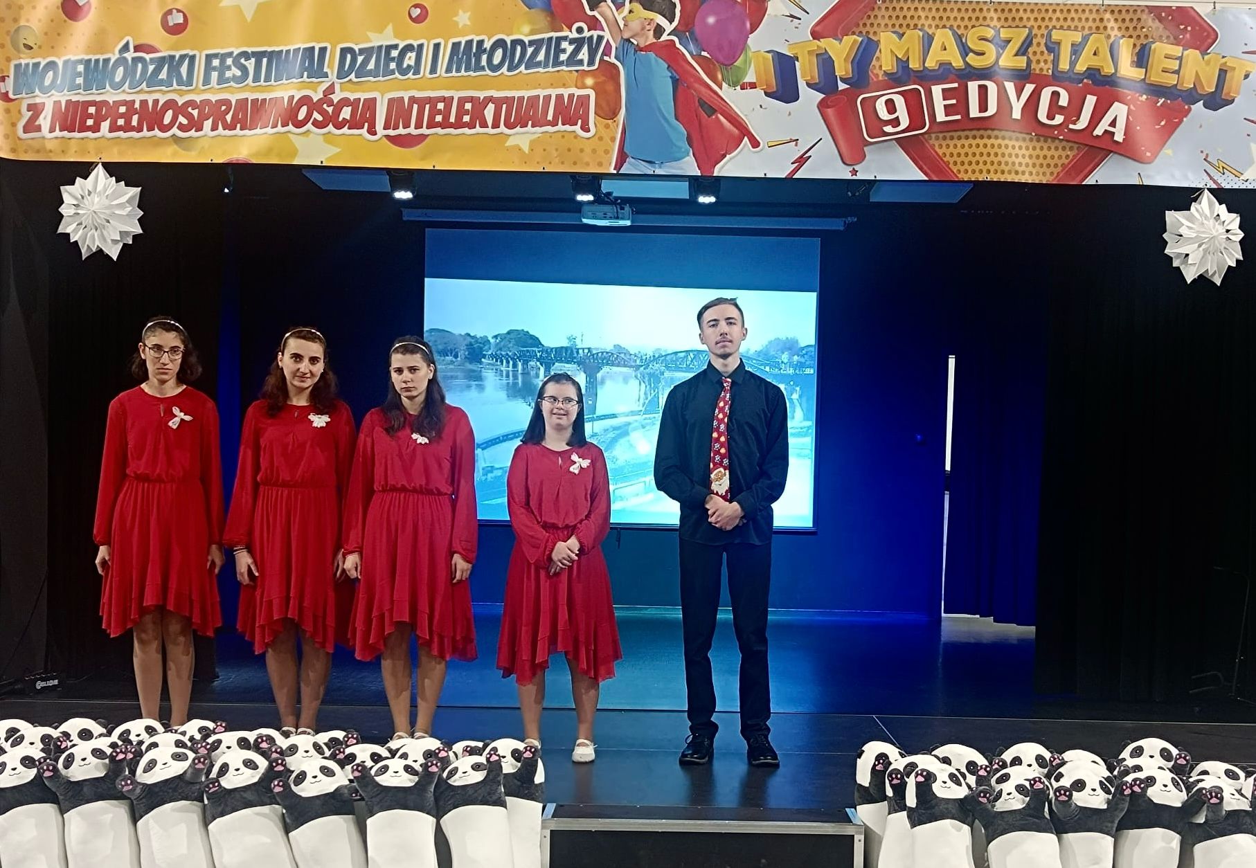 I miejsca dla chóru szkolnego „Karolus” | Cztery dziewczyny i chłopak stoją na scenie.jpg