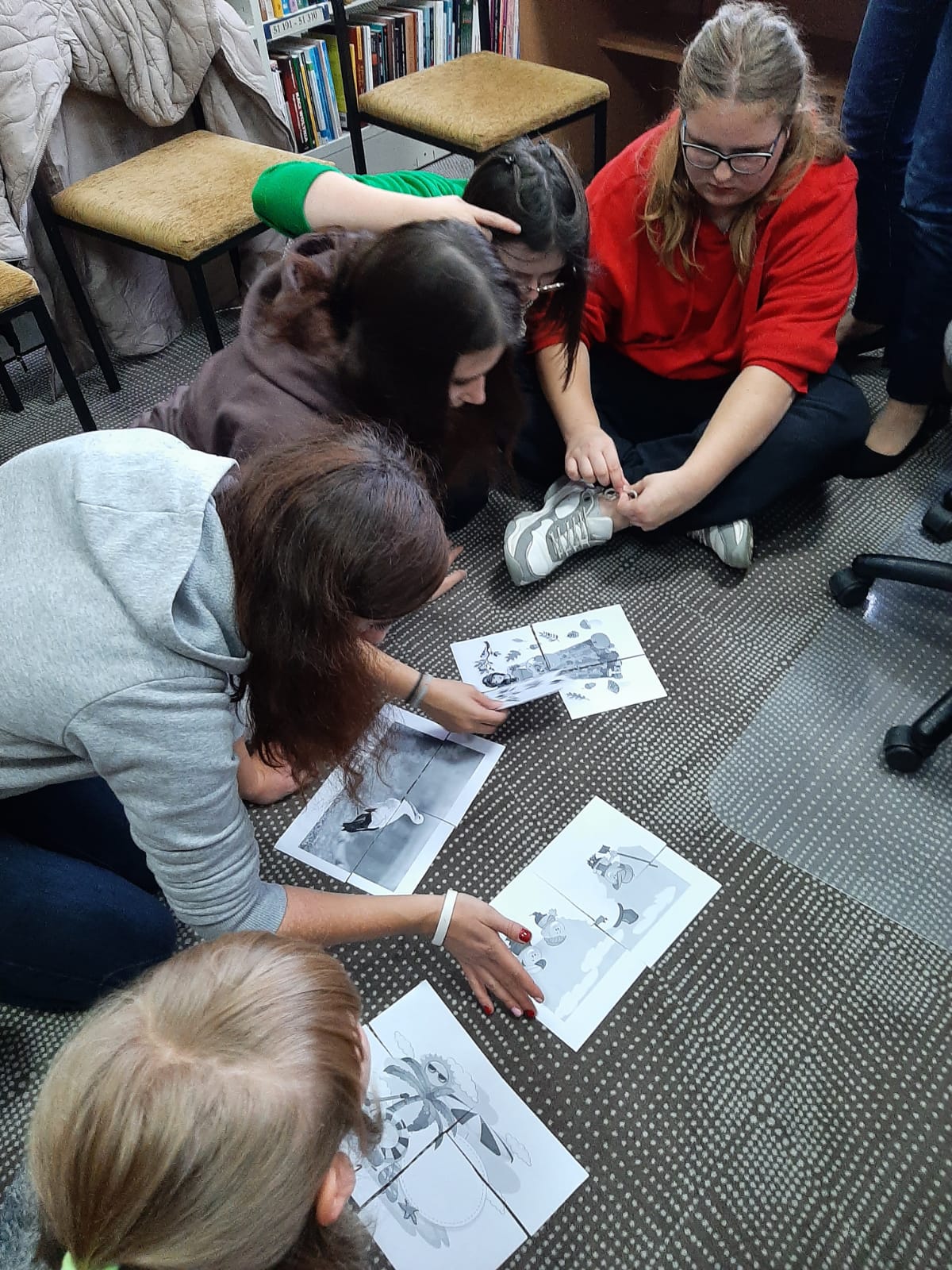 Pozalekcyjne zajęcia w bibliotece | Uczniowie na dywanie ukladaja obrazki.jpg