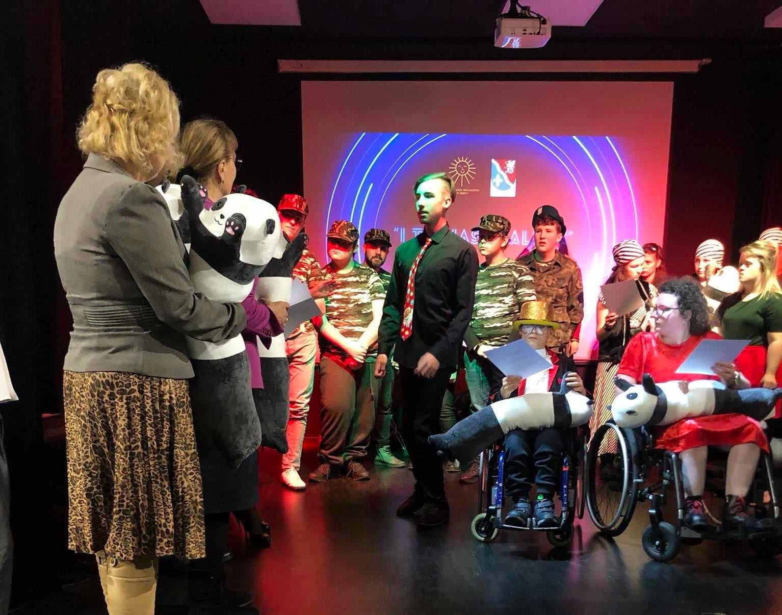 I miejsca dla chóru szkolnego „Karolus” | Chłopak odbiera na scenie nagrodę od organizatorów.jpg