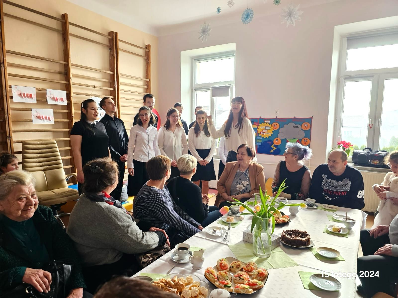 Dzień Babci i Dziadka w przedszkolu | Babcie oglądają występ chóru szkolnego.jpg