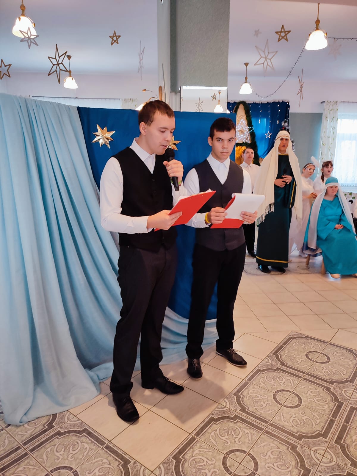 Nasz szkolny chór Karolus, zawsze obecny podczas uroczystości i wydarzeń muzycznych w naszym środowisku, zdobywa również uznanie na zewnątrz, biorąc udział w festiwalach i konkursach.  Gratulujemy wszystkich osiągnięć, zwłaszcza tych ostatnich, jakimi było zdobycie pierwszych miejsc na XI Wojewódzkim Festiwalu Piosenki Patriotycznej, Żołnierskiej i Harcerskiej Placówek Kształcenia Specjalnego w Rudniku nad Sanem oraz IX Wojewódzkim Festiwalu Dzieci i Młodzieży z Niepełnosprawnością Intelektualną w Dębicy.  Jesteśmy z was dumni! | Dwóch uczniów w biało-czarnym stroju z mikrofonem.jpg