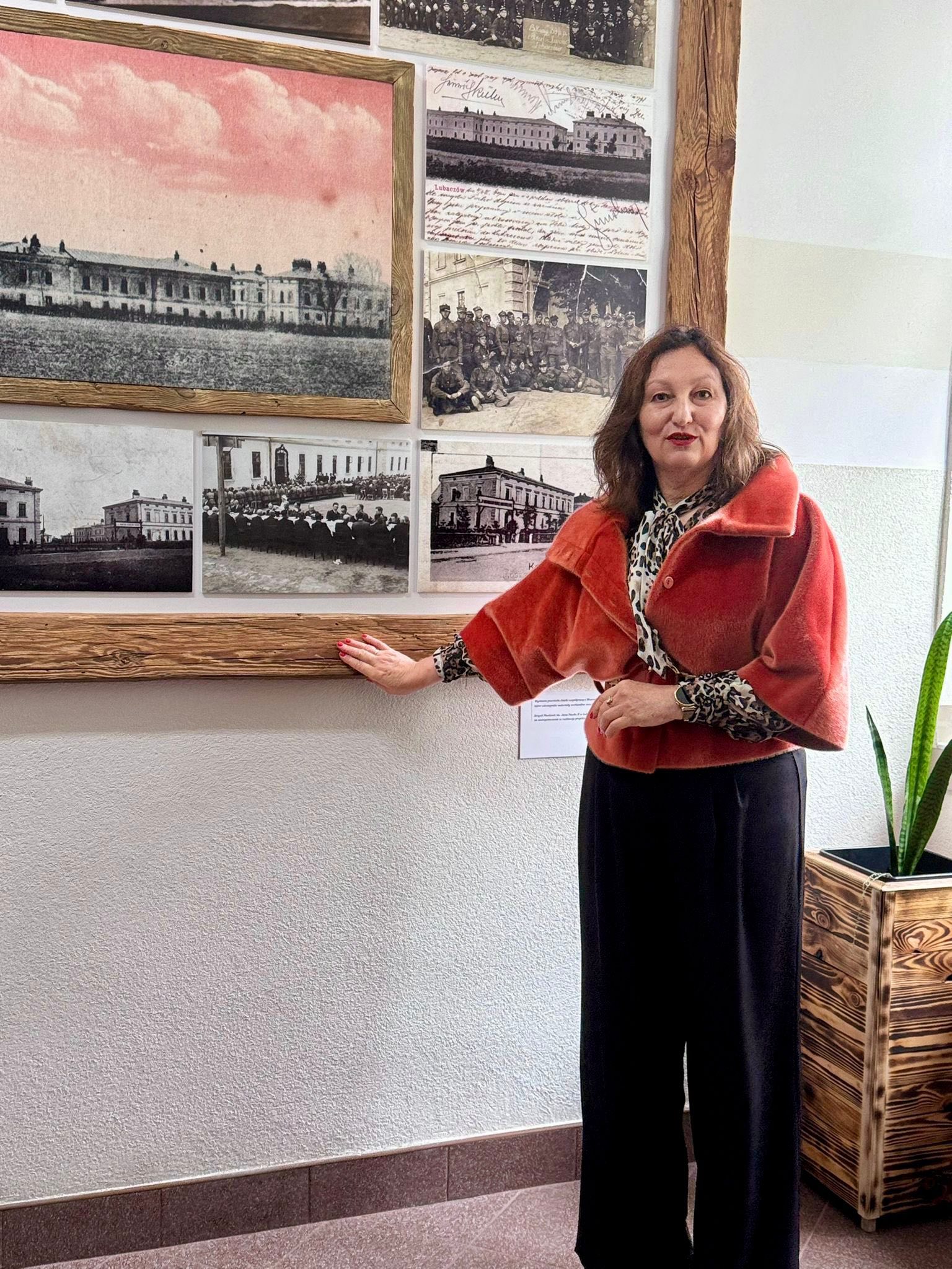 Święto Szkoły 2025 | Kobieta w czerwonym futerku prezentuje wystawę zdjęcia.jpg