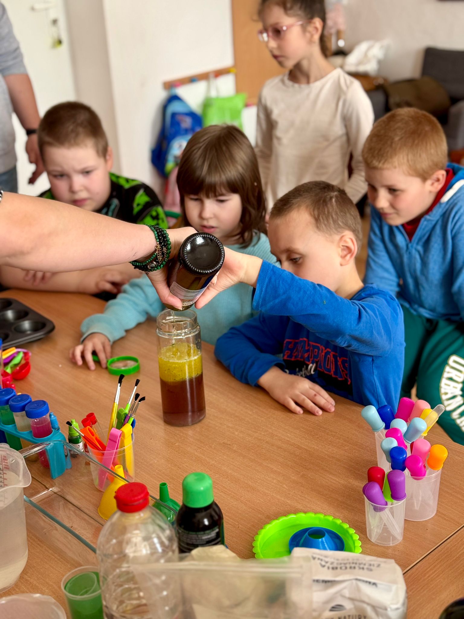 Podsumowanie IV edycji programu grantowego „Rosnę z matematyką” | Dzieci wlewają płyn do bytelki.jpg