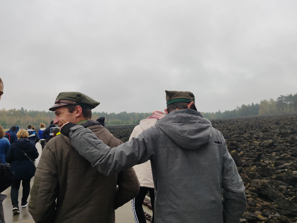 Bełżec – Miejsce Pamięci | Dwóch uczniów spaceruje tyłem do aparatu.jpg