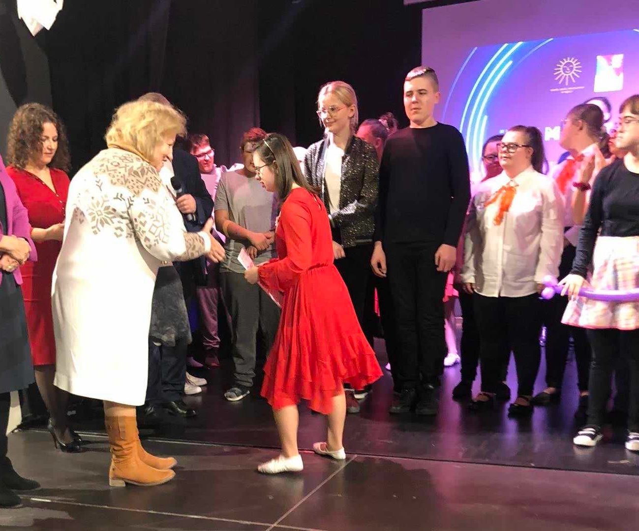 I miejsca dla chóru szkolnego „Karolus” | Dziewczyna odbiera na scenie nagrodę od organizatorów.jpg