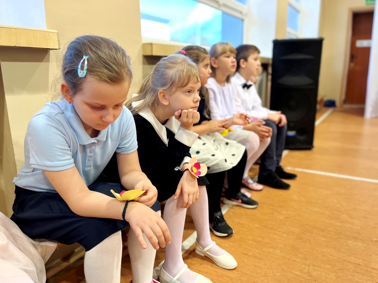 Świętujemy Dzień Edukacji Narodowej | uczniowie siedzą na ławeczce i czekają na występ.JPG