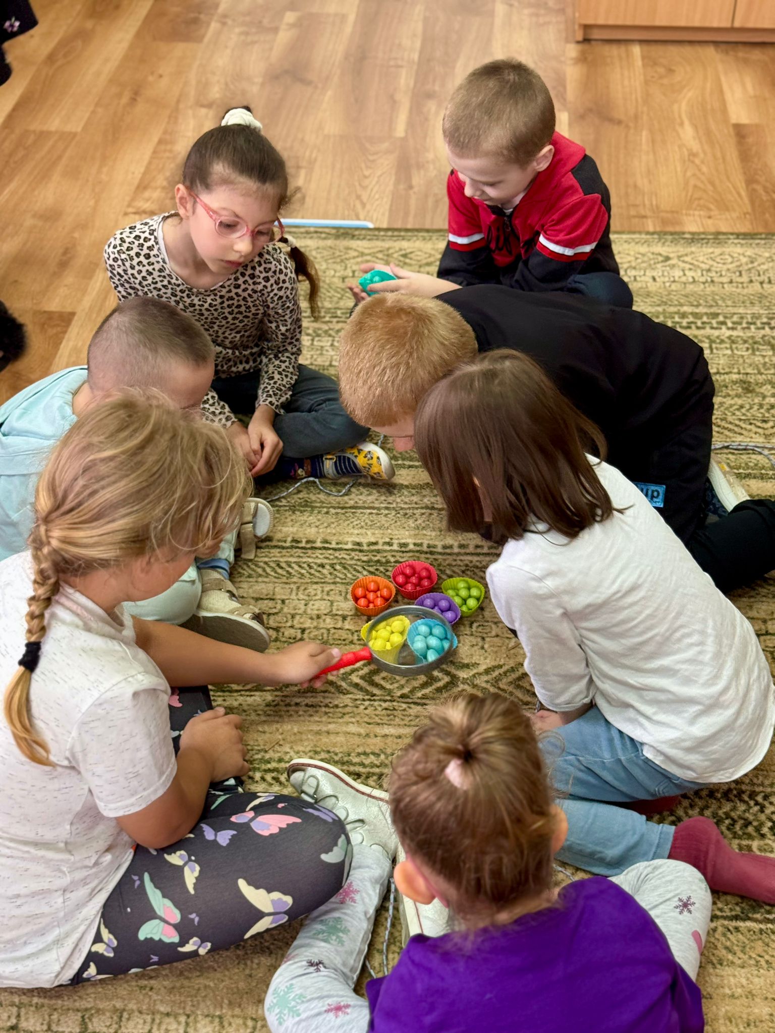 Podsumowanie IV edycji programu grantowego „Rosnę z matematyką” | Dzieci siedzą na dywanie w środku kolorowe kulki.jpg