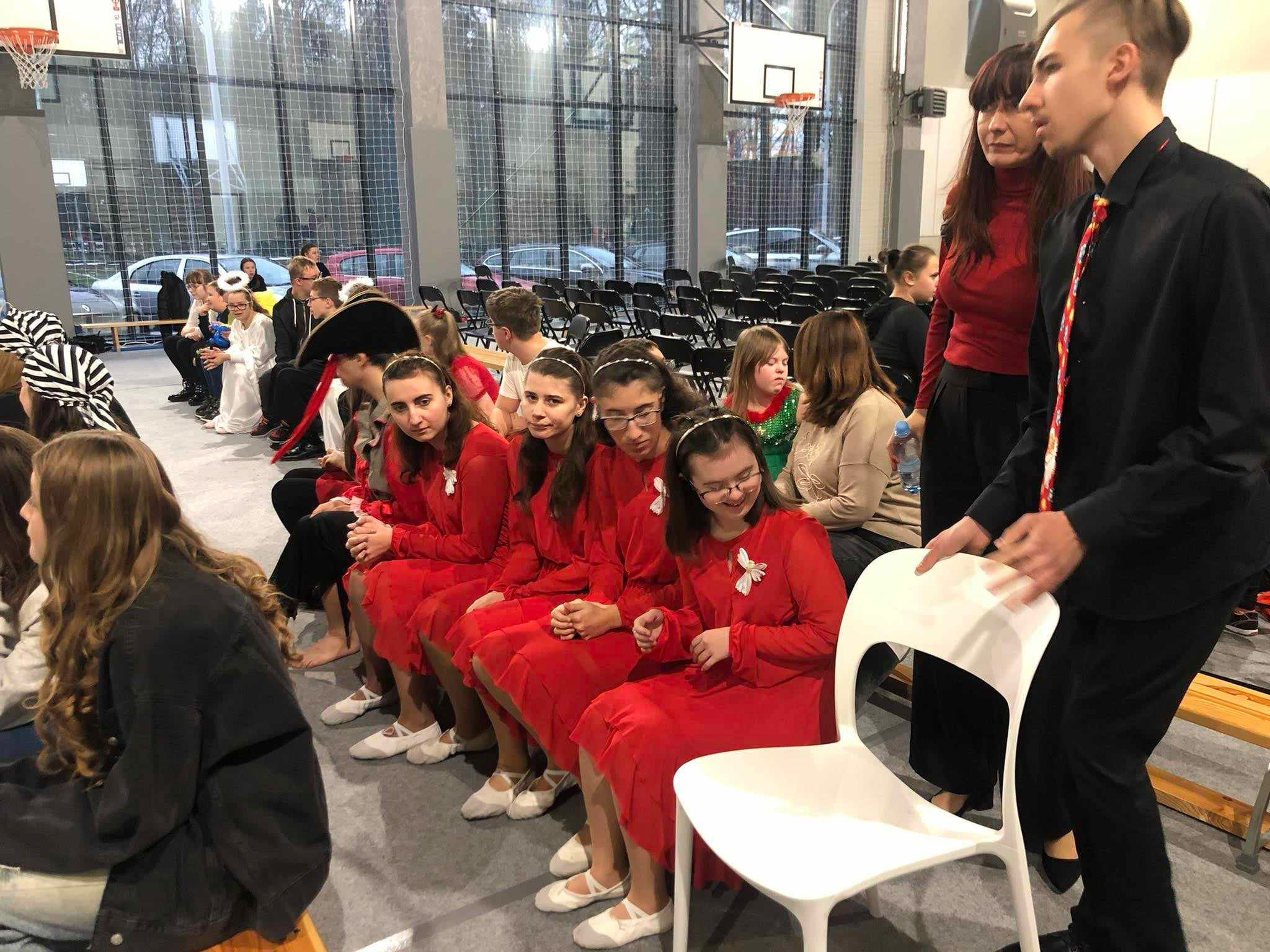 I miejsca dla chóru szkolnego „Karolus” | Dziewczyny i chłopach siedzą na widowni.jpg