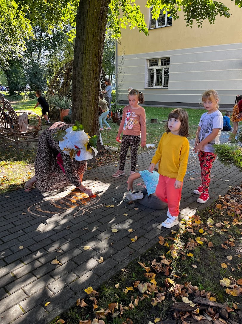 Powitanie Jesieni | Dzieci z panią wiosną malują kredą na chodniku.jpg