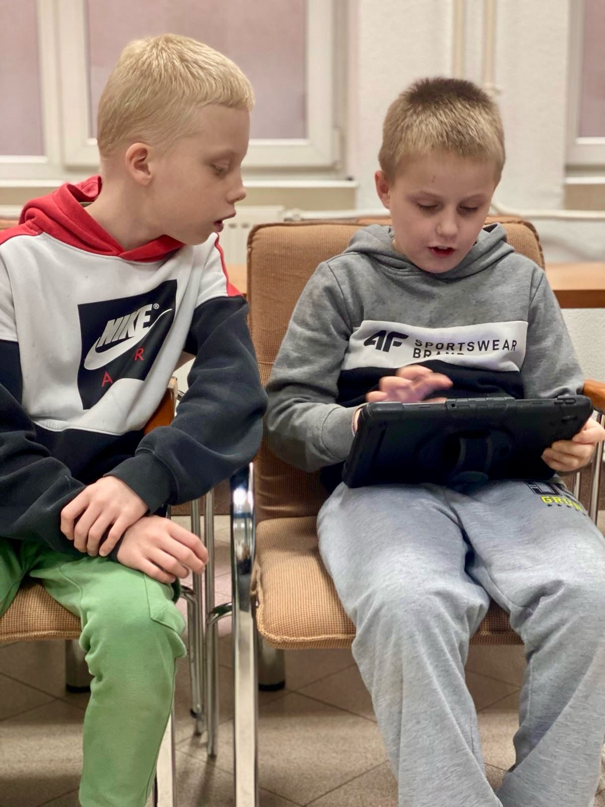 ROBOTYKA | Dwóch chłopców siedzi na krzesłach i ogladają tablet.jpg