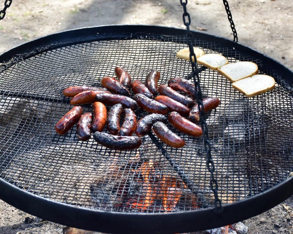 Na rowerach po okolicy | Zbliżenie rusztu z upieczonymi kiełbaskami i kromkami chleba.JPG