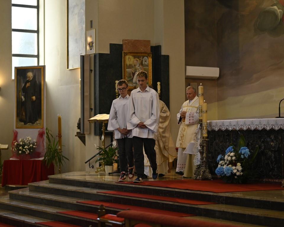 Święto Szkoły- XVII rocznica nadania imienia Jana Pawła II | Dwóch ministrantów zbliża się do schodków prowadzących od ołtarza. Za nimi idą dwaj księża w ormatach. W tle fragment ołtarza.JPG