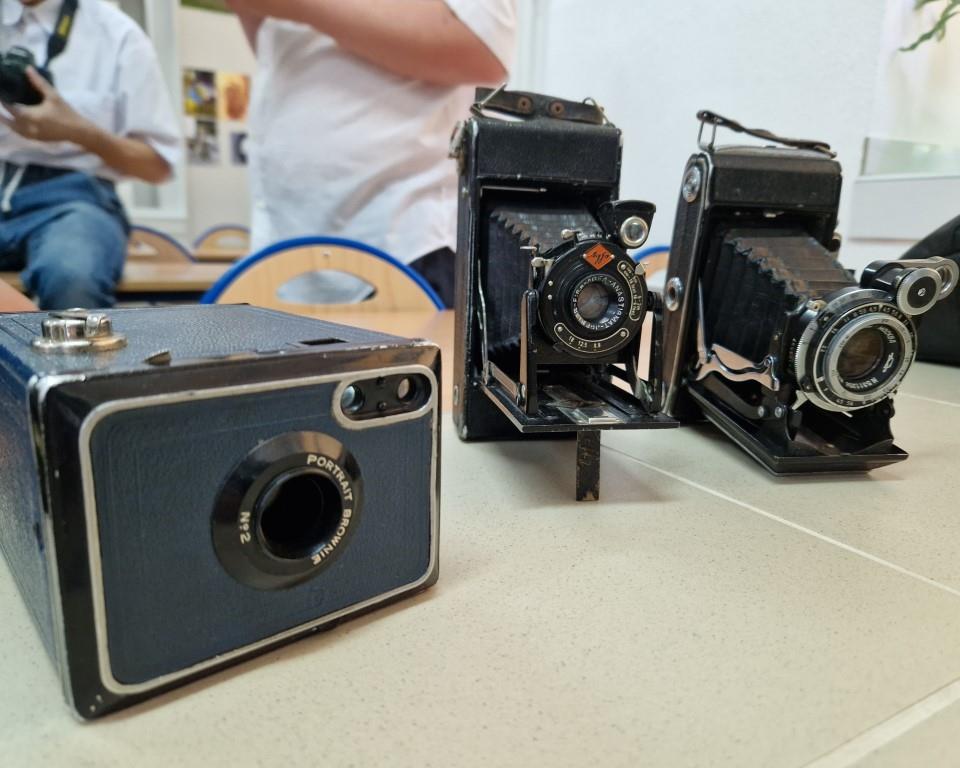 Święto Szkoły- XVII rocznica nadania imienia Jana Pawła II | Leżące na blacie trzy zabytkowe aparaty fotograficzne.jpg