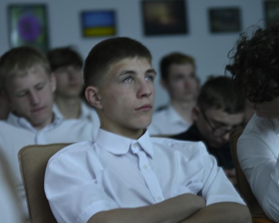 Święto Szkoły- XVII rocznica nadania imienia Jana Pawła II | Zbliżenie na siedzących na krzesłach chłopców w białych koszulach.JPG