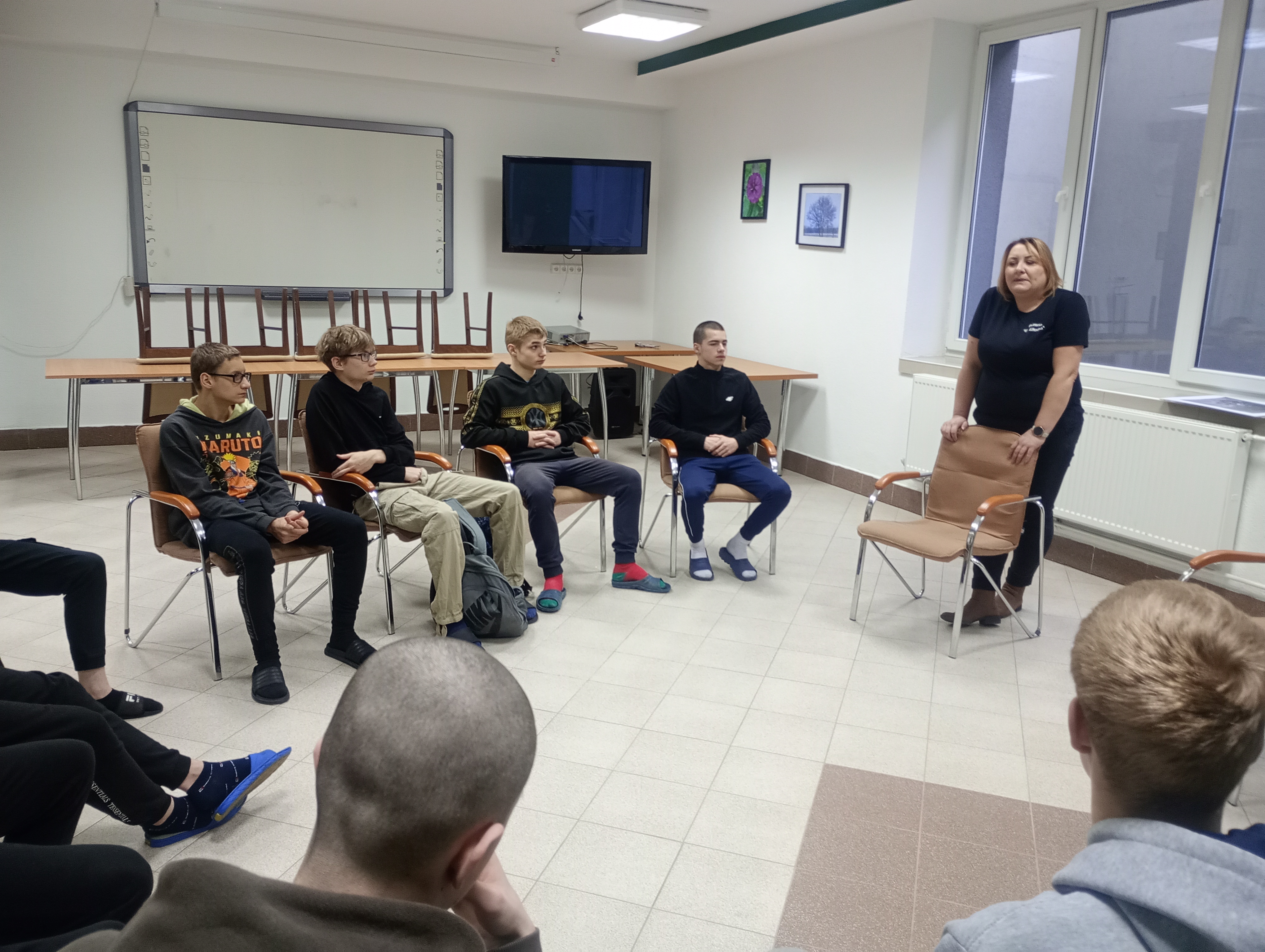 Spotkanie z pracodawcą w ramach Projektu Kariera bez Barier | W sali multimedialnej naszego ośrodka trwa spotkanie z właścicielka pizzerii. Wychowankowie siedza w kręgu a przed nimi stoi prowadząca..jpg