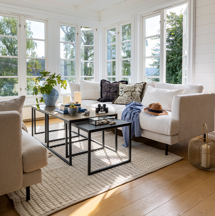 Lyse stuemøbler gir en avslappet og sommerlig stil til hytta. I Stockholm sofa er det godt å slappe av etter en lang dag på sjøen eller en tur i skogen.