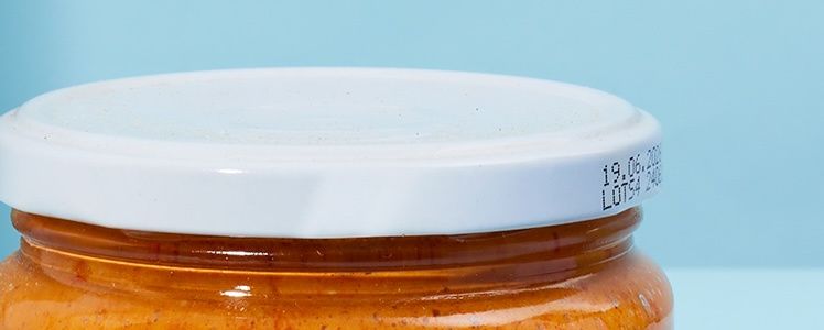 Nahaufnahme eines verschlossenen Aufstrich-Glasgefäßes von KoRo mit weißem Schraubdeckel und aufgedrucktem Mindesthaltbarkeitsdatum.