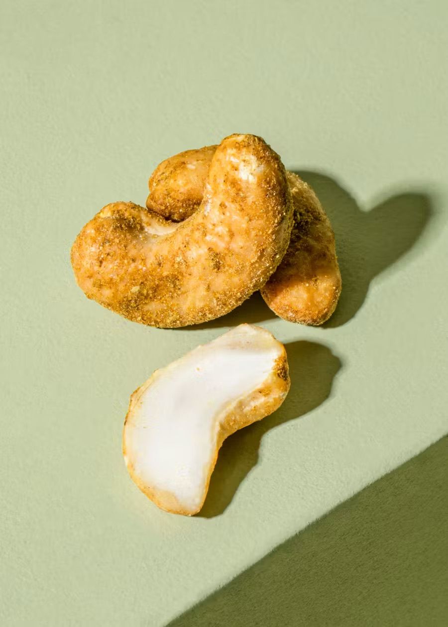 gewürzte Cashewkerne liegen auf einem hellen Untergrund