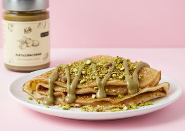 vegane Crêpes auf einem Teller geschichtet mit Pistaziencreme