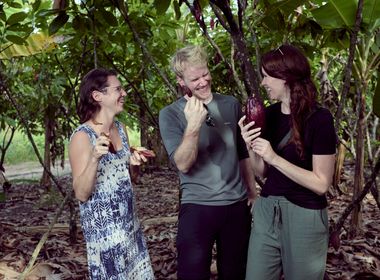 KoRo-CEO Flo und Head of Sustainability Christina auf einer Kakaoplantage in Peru beim Begutachten frisch geernteter, purpurroter Kakaoschoten.