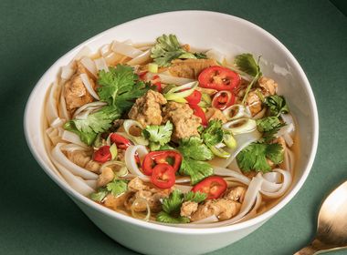 Asiatische Seitan-Nudelsuppe mit Reisnudeln, Frühlingszwiebeln und Chilis in klarer Brühe