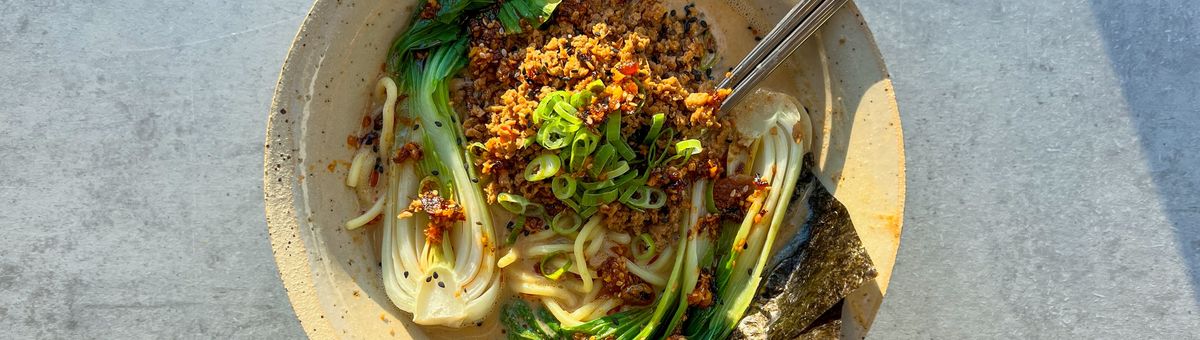Vegane Tantan Ramen mit Ramen-Nudeln, Baby Pak Choi, würzigem Sojaschnetzel-Topping, Frühlingszwiebeln und Nori in cremiger, scharfer Brühe – asiatische Nudelsuppe in Keramikschale