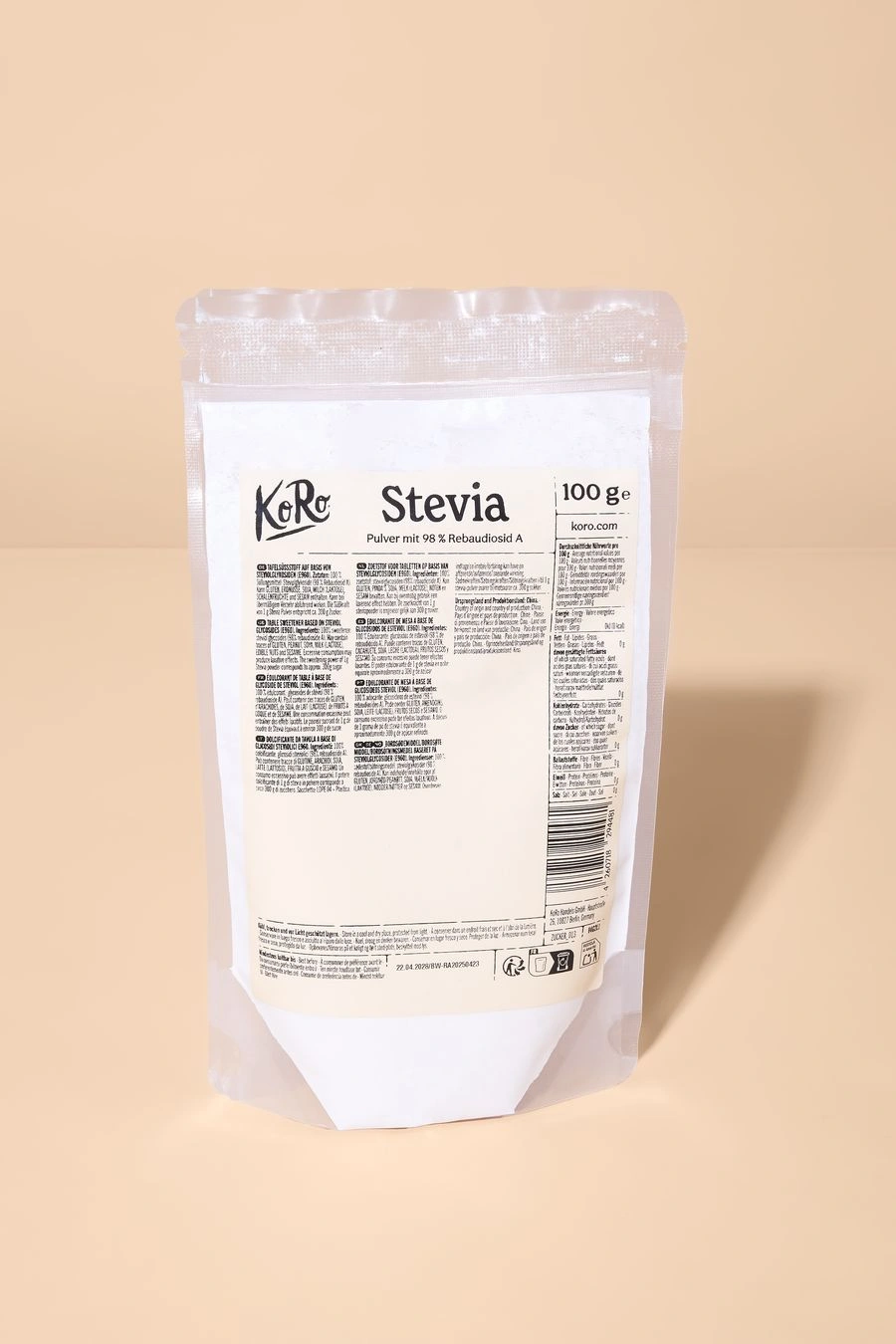 Eine 100-g-Packung KoRo Stevia-Pulver in einem transparenten Standbeutel vor einem schlichten, beigefarbenen Hintergrund.