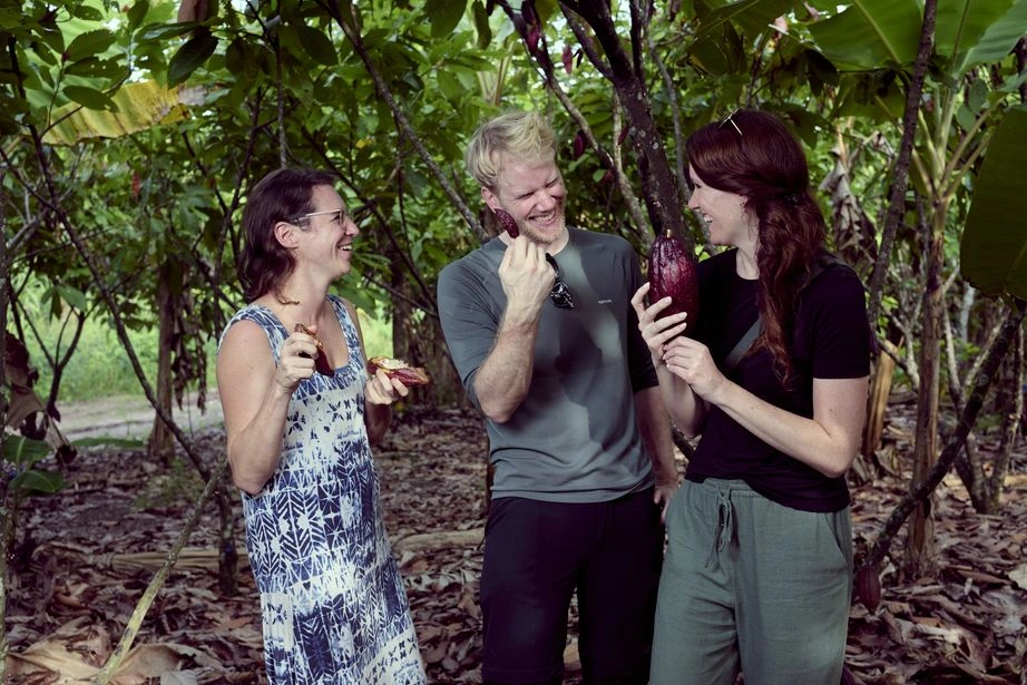 KoRo-CEO Flo und Head of Sustainability Christina auf einer Kakaoplantage in Peru beim Begutachten frisch geernteter, purpurroter Kakaoschoten.