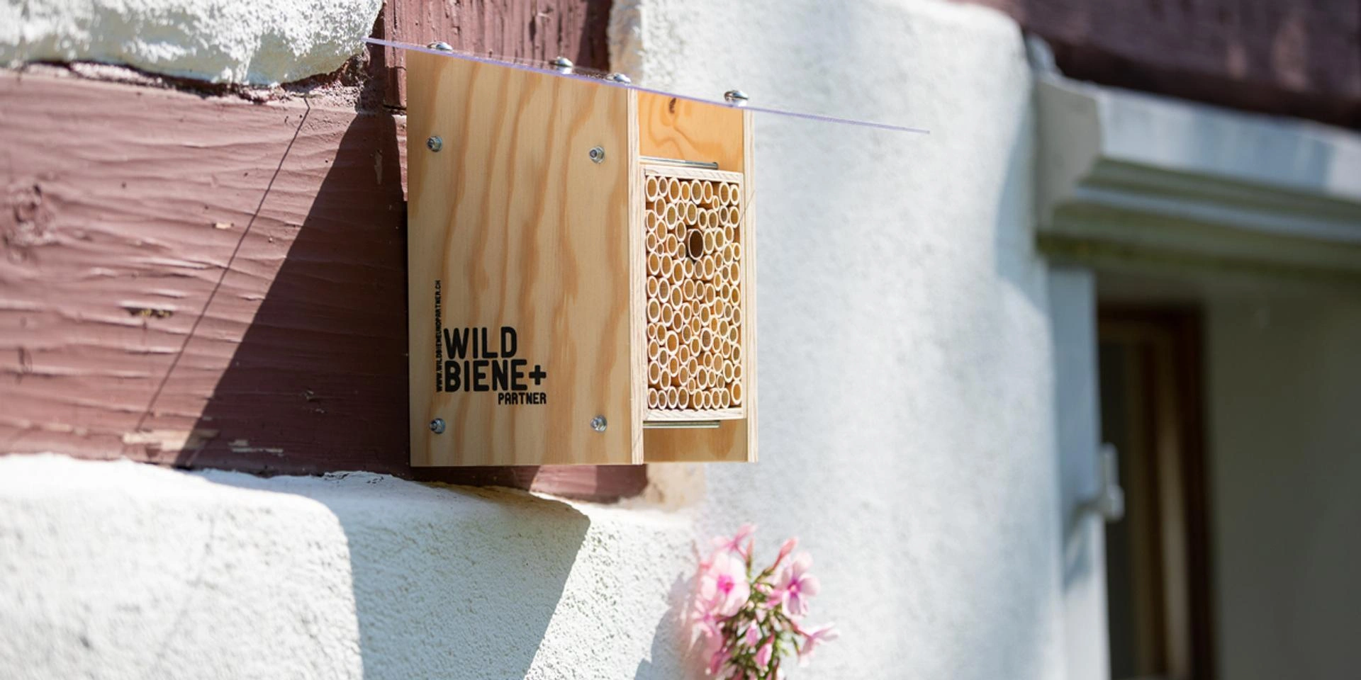 Wildbiene+ Partner Bienenhaus aus Holz mit Röhren an Hauswand montiert