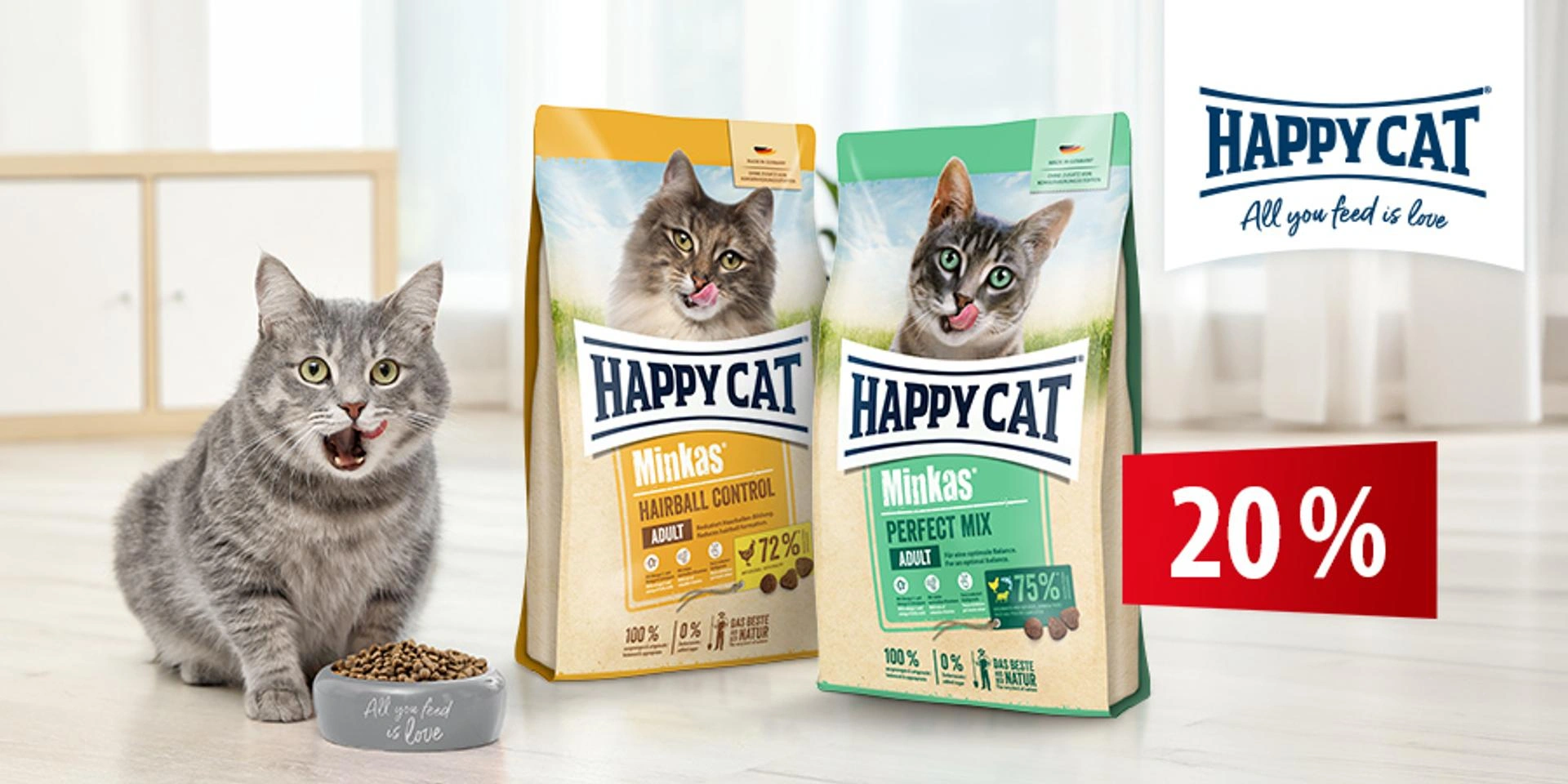 Happy Cat Minkas Katzenfutter mit 20 % Rabatt neben einer grauen Katze und zwei Trockenfutterverpackungen in heller Wohnumgebung