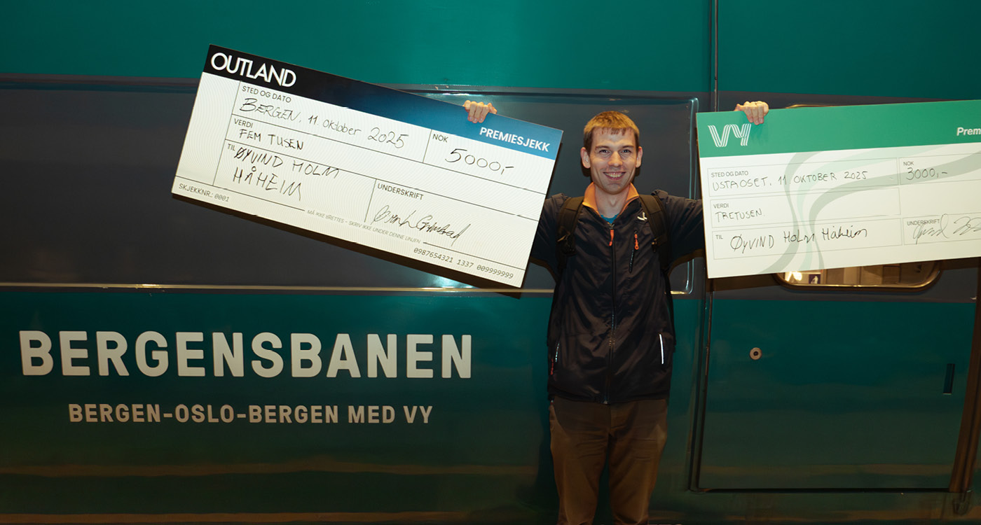 Øyvind, Norgesmester i Ticket to Ride 2025 poserer med gavesjekker fra Outland og Vy foran togvogn
