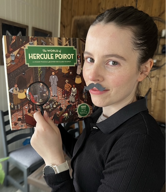 Verdensmester i puslespill 2024 Kristin Thuv med lupe, falsk bart og puslespillet The World of Hercule Poirot