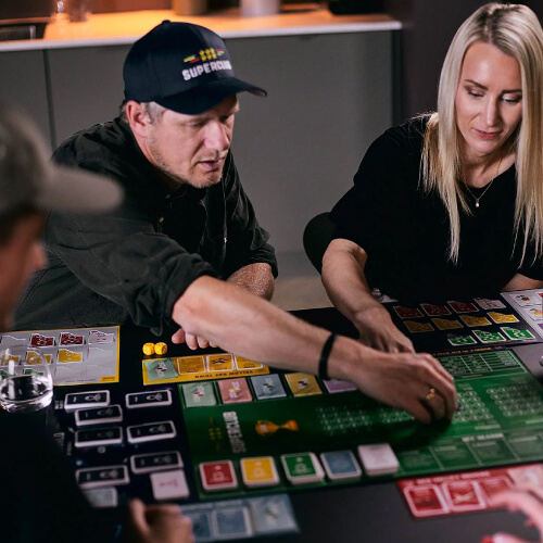 Mann plasserer spillbrikker på Suprclub-brett