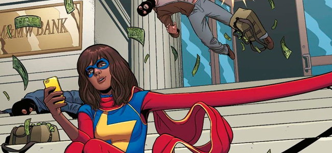  Ms. Marvel sitter utenfor en bank mens hun scroller på mobilen, samtidig som hun hindrer et bankran