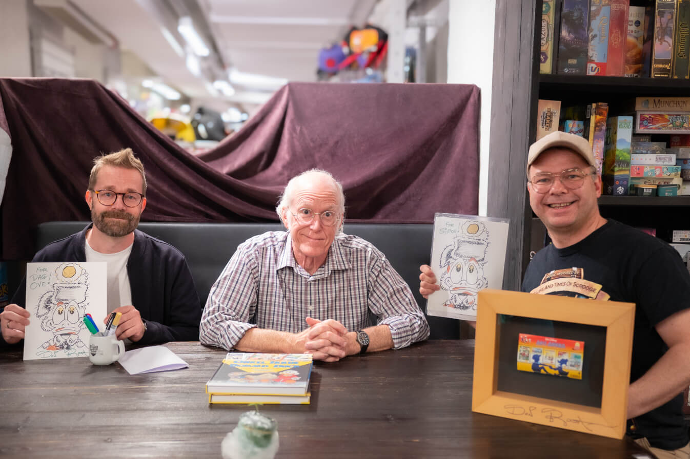 Don Rosa poserer med to fans med signerte Skrue McDuck-tegninger