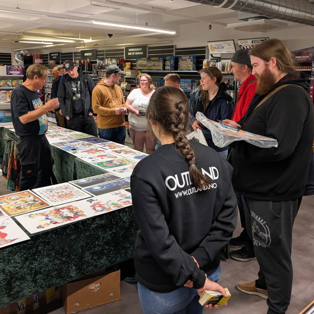 Outland-ansatte og kunder rundt langbord med Don Rosa-trykk