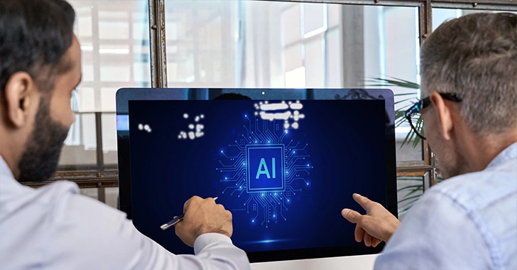 Two individuals collaborating in an office, focusing on a computer screen displaying a digital circuit board with 'AI' prominently featured, symbolizing artificial intelligence and teamwork.