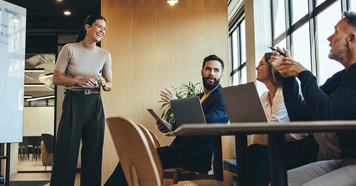 Four professionals in a modern office setting engaged in a collaborative session.