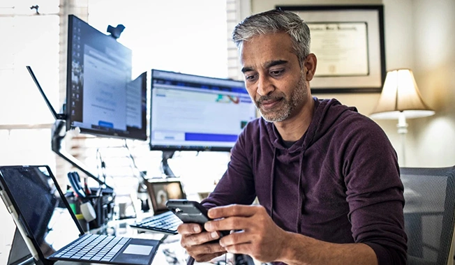 man in front of two screens