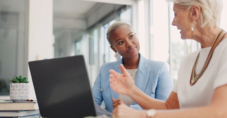 Two individuals in a modern office setting engaged in a professional discussion