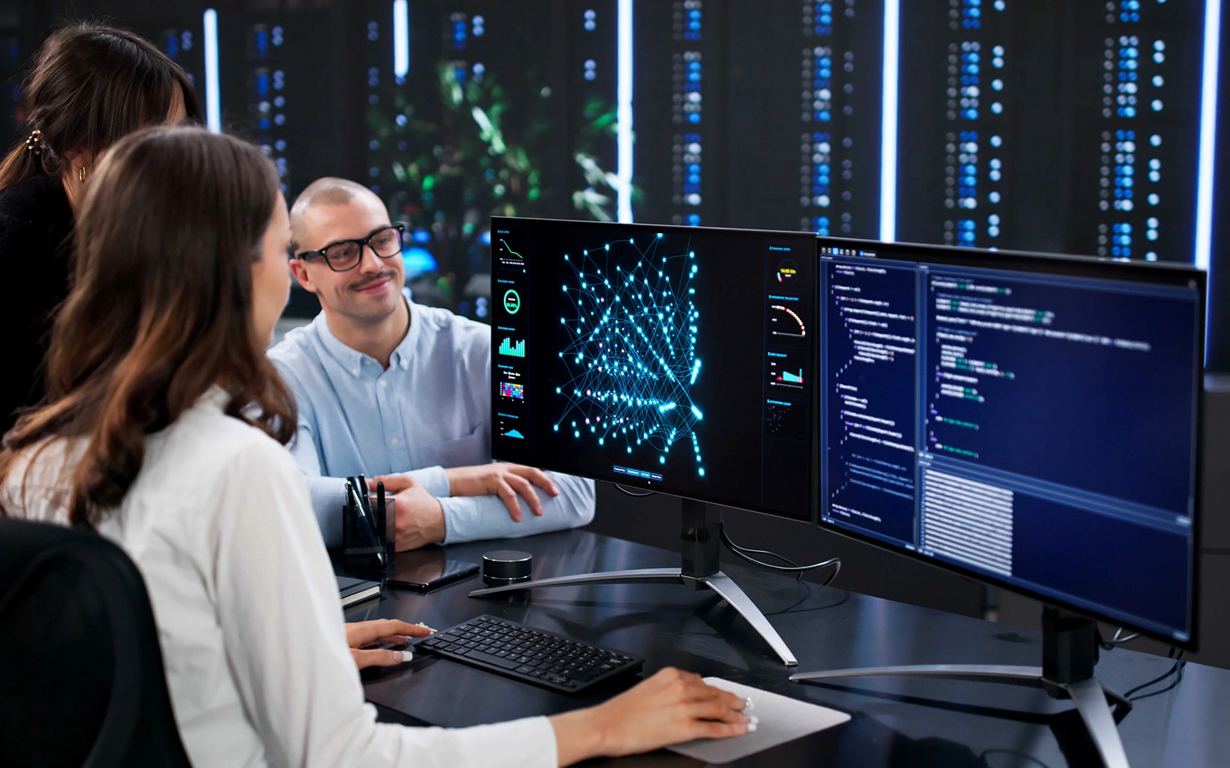 Team members reviewing AI analytics and data visualizations on multiple computer screens in a modern office.