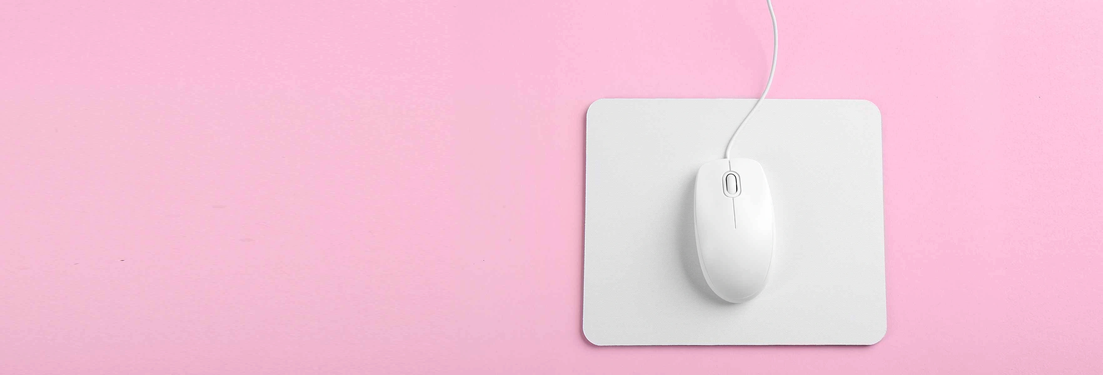 a white mouse on a white mouse mat on a pink background